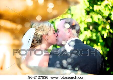 happy couple kissing behind the fountain View Large Photo Image Stock Photograph - happy couple kissing behind the fountain. Fotosearch