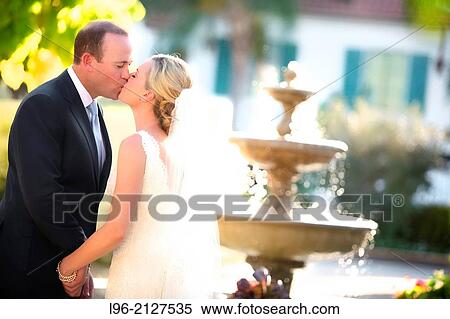 happy couple kissing in front of a fountain View Large Photo Image Stock Photography - happy couple kissing in front of a fountain. Fotosearch