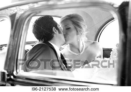 happy couple kissing while getting away in a vintage car after their wedding View Large Photo Image Stock Photo - happy couple kissing while getting away in a vintage car after their wedding. Fotosearch