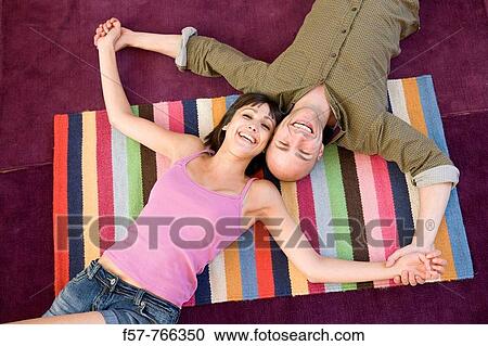 Happy couple lying on the floor View Large Photo Image Stock Image - Happy couple lying on the floor. Fotosearch