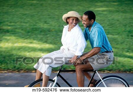 happy couple on a bicycle View Large Photo Image Stock Photograph - happy couple on a bicycle. Fotosearch