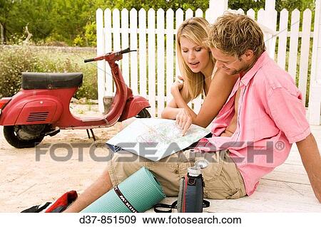 Happy couple on a country trip looking up in a map View Large Photo Image Stock Photo - Happy couple on a country trip looking up in a map. Fotosearch