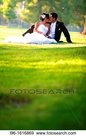 happy couple sitting in grass embracing after wedding View Large Photo Image Stock Photo - happy couple sitting in grass embracing after wedding. Fotosearch