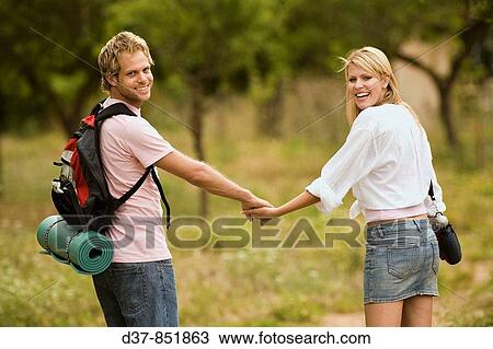 Happy couple walking hand in hand in the country View Large Photo Image Stock Image - Happy couple walking hand in hand in the country. Fotosearch