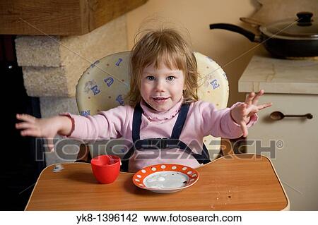 Happy Dirty Two Year Old Caucasian Kid Girl Sitting and Playing in High Chair View Large Photo Image Stock Image - Happy Dirty Two Year Old Caucasian Kid Girl Sitting and Playing in High Chair. Fotosearch