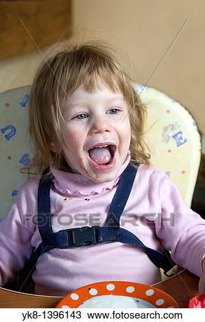 Happy Dirty Two Year Old Caucasian Kid Girl Sitting and Shouting in High Chair View Large Photo Image Stock Image - Happy Dirty Two Year Old Caucasian Kid Girl Sitting and Shouting in High Chair. Fotosearch