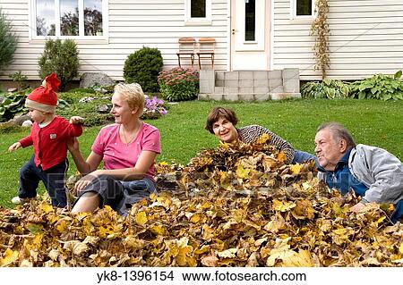 Picture - Happy Elderly Senior Grandparents with Kid Girl and Mother in Fall Leaves. Fotosearch