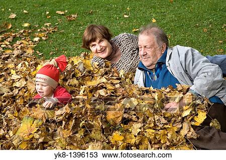 Happy Elderly Senior Grandparents with Kid Girl in Fall Leaves View Large Photo Image Stock Image - Happy Elderly Senior Grandparents with Kid Girl in Fall Leaves. Fotosearch