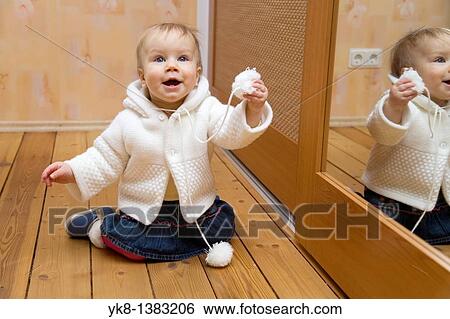 Stock Photograph - Happy Emotional Smiling Ten Month Old Baby Kneel Down. Fotosearch