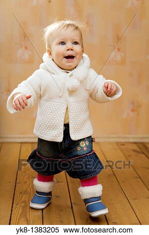 Stock Photography - Happy Emotional Smiling Ten Month Old Baby Walking First Steps. Fotosearch