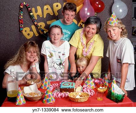Picture - Happy family groups at ten year-old's birthday party posing for the camera. Fotosearch