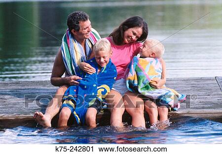 Stock Image - happy family of four on a dock. Fotosearch