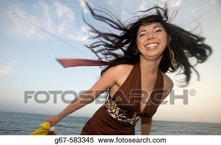 Stock Photography - Happy girl Ella twirls at a beach in Southern california at dusk.. Fotosearch