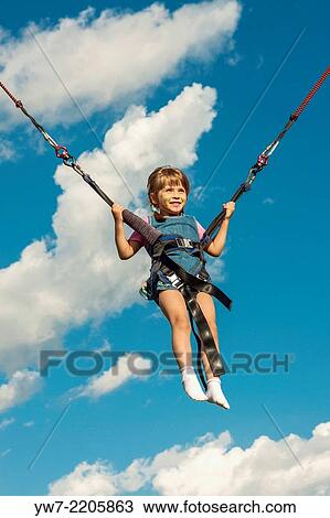 Happy girl jumping on a trampoline. View Large Photo Image Stock Image - Happy girl jumping on a trampoline.. Fotosearch