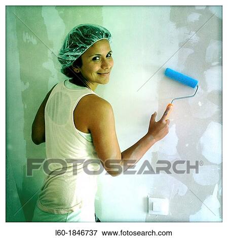 Happy girl painting in her new home View Large Photo Image Stock Photo - Happy girl painting in her new home. Fotosearch