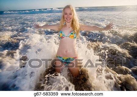 Happy girl plays in the surf at a beach in California, USA at dusk View Large Photo Image Stock Photo - Happy girl plays in the surf at a beach in California, USA at dusk. Fotosearch
