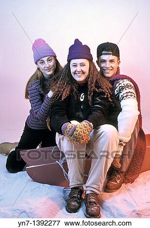 Happy group of three teenagers rugged up against the cold of the surrounding snow View Large Photo Image Stock Photo - Happy group of three teenagers rugged up against the cold of the surrounding snow. Fotosearch
