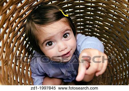 Happy little girl playing peekaboo and hides inside a basket. View Large Photo Image Stock Photography - Happy little girl playing peekaboo and hides inside a basket.. Fotosearch