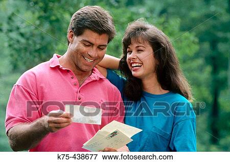 Happy looking at photos and a letter View Large Photo Image Stock Photo - Happy looking at photos and a letter. Fotosearch