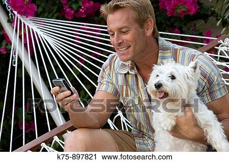 Happy man in hammock with his pet dog View Large Photo Image Stock Image - Happy man in hammock with his pet dog. Fotosearch