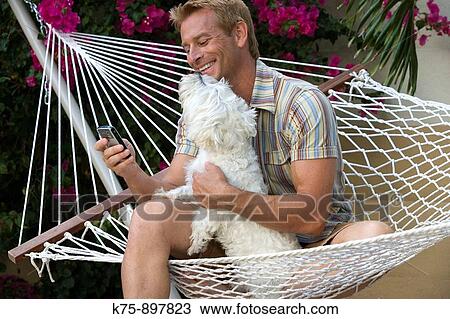 Happy man in hammock with his pet dog View Large Photo Image Stock Image - Happy man in hammock with his pet dog. Fotosearch
