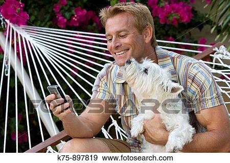 Happy man in hammock with his pet dog View Large Photo Image Stock Photo - Happy man in hammock with his pet dog. Fotosearch
