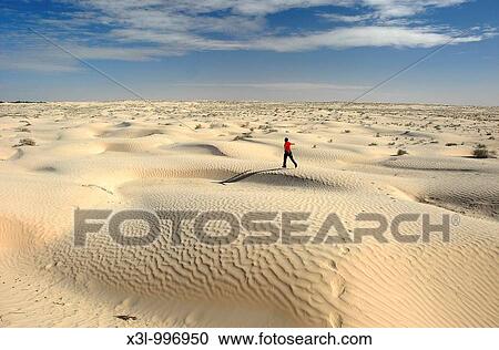 Stock Image - Happy man running in Douz desert Tunisia. Fotosearch