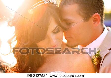 happy married couple enjoying a moment, embracing at sunset View Large Photo Image Picture - happy married couple enjoying a moment, embracing at sunset. Fotosearch