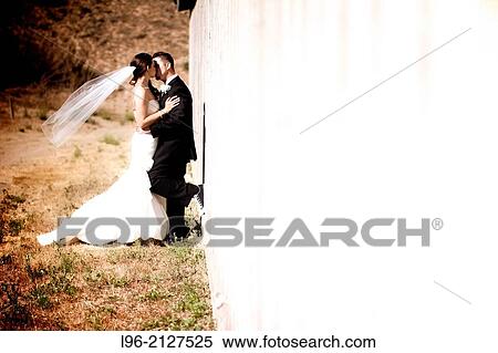 happy married couple kiss and embrace leaning against a barn View Large Photo Image Stock Photography - happy married couple kiss and embrace leaning against a barn. Fotosearch