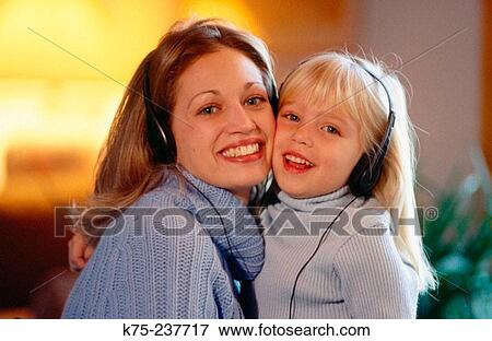 Happy mom and daughter listening to music View Large Photo Image Stock Photo - Happy mom and daughter listening to music. Fotosearch