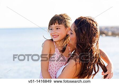 Happy mother carrying her daughter at the beach View Large Photo Image Stock Photo - Happy mother carrying her daughter at the beach. Fotosearch