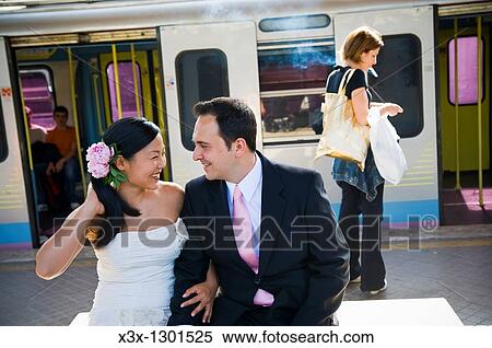 Happy multi-ethnic bride and groom looking at each other in train station View Large Photo Image Stock Photography - Happy multi-ethnic bride and groom looking at each other in train station. Fotosearch
