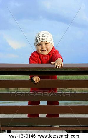Happy one year girl on a bench View Large Photo Image Stock Photograph - Happy one year girl on a bench. Fotosearch