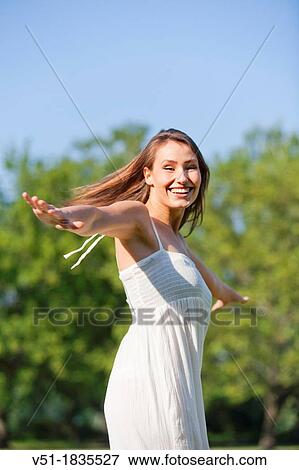 Stock Photo - Happy pretty woman enjoying in park. Fotosearch