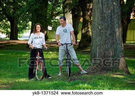Happy Smiling Couple in Park with Bicycles, Estonia View Large Photo Image Picture - Happy Smiling Couple in Park with Bicycles, Estonia. Fotosearch