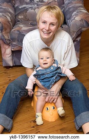 Stock Photo - Happy Smiling Mother and Infant Baby on Potty. Fotosearch