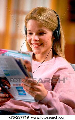 Happy teen reading a magazine View Large Photo Image Stock Photo - Happy teen reading a magazine. Fotosearch