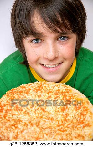 Stock Image - Happy teenage boy about to eat a pizza. Fotosearch