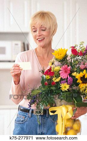 Stock Image - Happy to receive a beautiful bouquet of flowers. Fotosearch