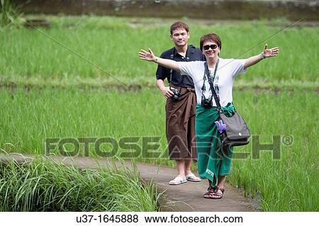 Happy tourists strolling along rice field of Goa Gajah The Elephant Cave Temple, Bedulu, Bali View Large Photo Image Stock Photo - Happy tourists strolling along rice field of Goa Gajah The Elephant Cave Temple, Bedulu, Bali. Fotosearch