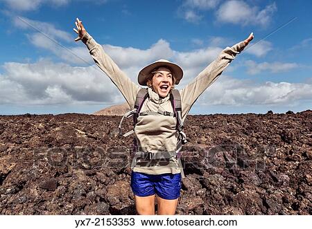 Stock Image - Happy woman hiking at Timanfaya National Park, Lanzarote, Canary Islands, Spain.. Fotosearch