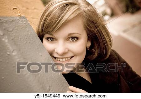 Happy, young Caucasian female leaning on wall View Large Photo Image Stock Photo - Happy, young Caucasian female leaning on wall. Fotosearch