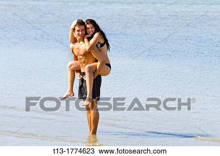Stock Image - Happy young couple on the beach. Fotosearch