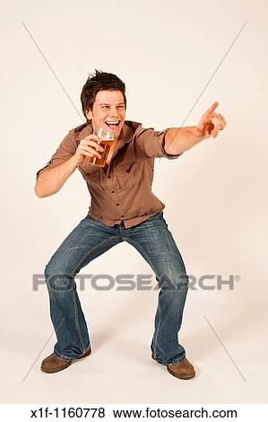 Happy young man drinking a pint of beer lager View Large Photo Image Stock Photo - Happy young man drinking a pint of beer lager. Fotosearch