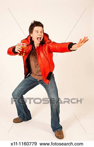Happy young man drinking a pint of beer lager View Large Photo Image Stock Photo - Happy young man drinking a pint of beer lager. Fotosearch