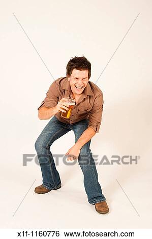 Happy young man drinking a pint of beer lager View Large Photo Image Stock Photograph - Happy young man drinking a pint of beer lager. Fotosearch