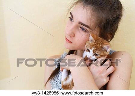 Stock Photograph - Happy young woman and red kitten. Fotosearch