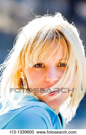 Stock Image - Happy young woman face, blowing wind. Fotosearch