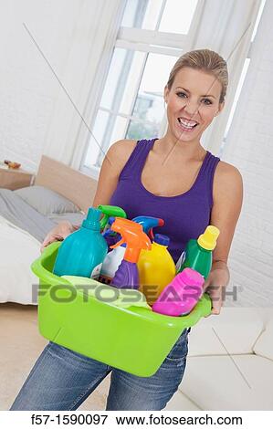 Happy young woman holding cleaning products View Large Photo Image Stock Photo - Happy young woman holding cleaning products. Fotosearch