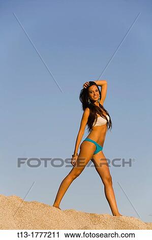 Happy young woman in a walking position atop a sand dune View Large Photo Image Stock Image - Happy young woman in a walking position atop a sand dune. Fotosearch